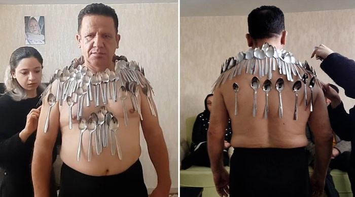 Iranian man breaks his own Guinness Record by balancing 96 spoons on body